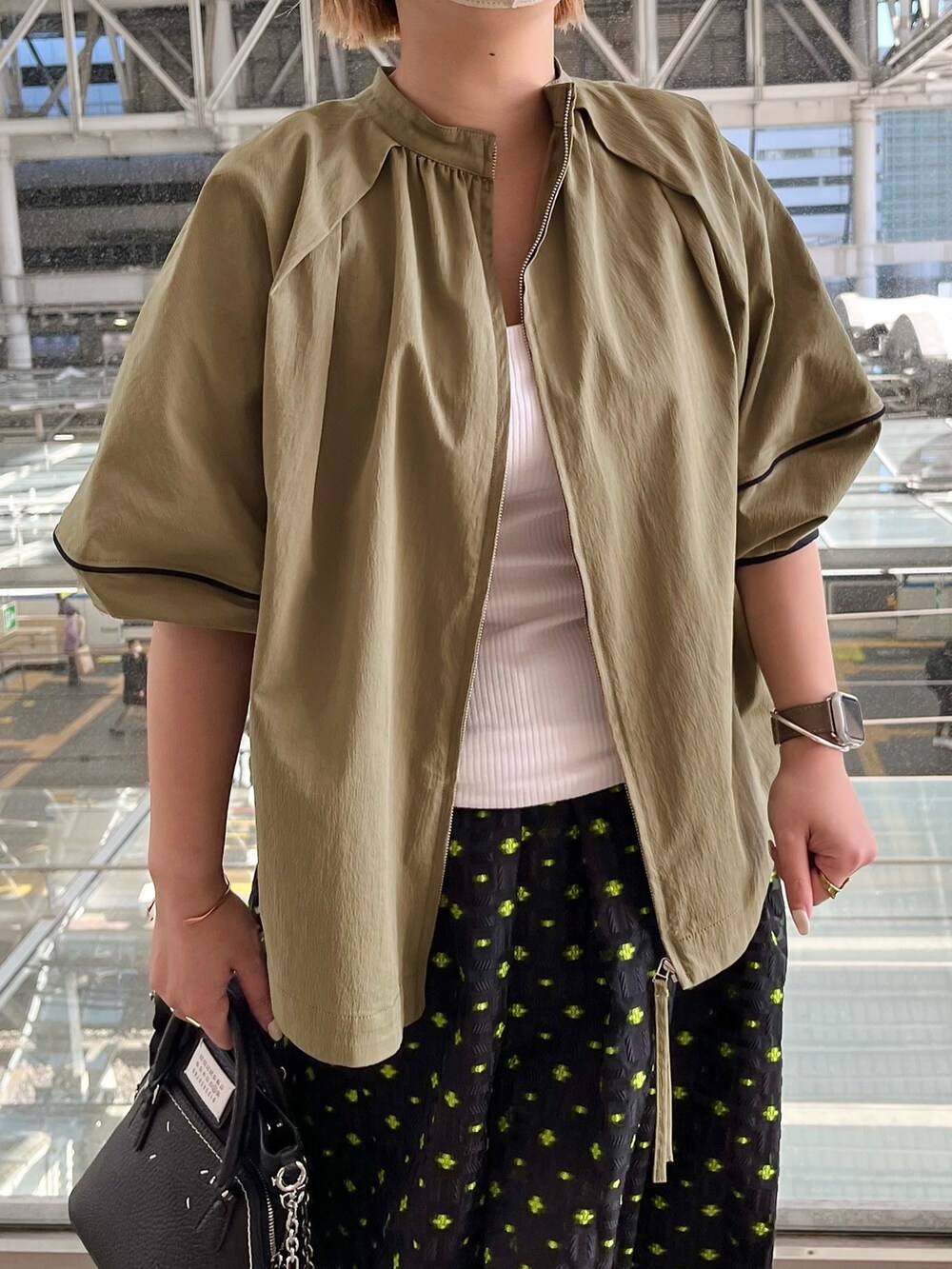 グリーン系のブルゾン、ホワイト系のタンクトップ、その他のスカートを着用したレディースの春コーディネートの4枚目の写真