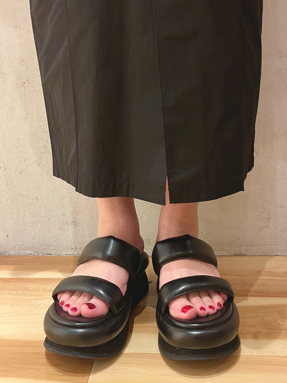 グリーン系のシャツ/ブラウス、ブラック系のスカート、ブラック系のサンダルを着用したレディースの冬コーディネートの9枚目の写真