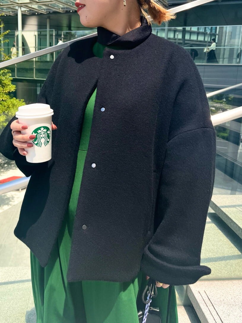 グリーン系のワンピース、ホワイト系のショルダーバッグ、ブラック系のノーカラーコートを着用したレディースの夏コーディネートの5枚目の写真