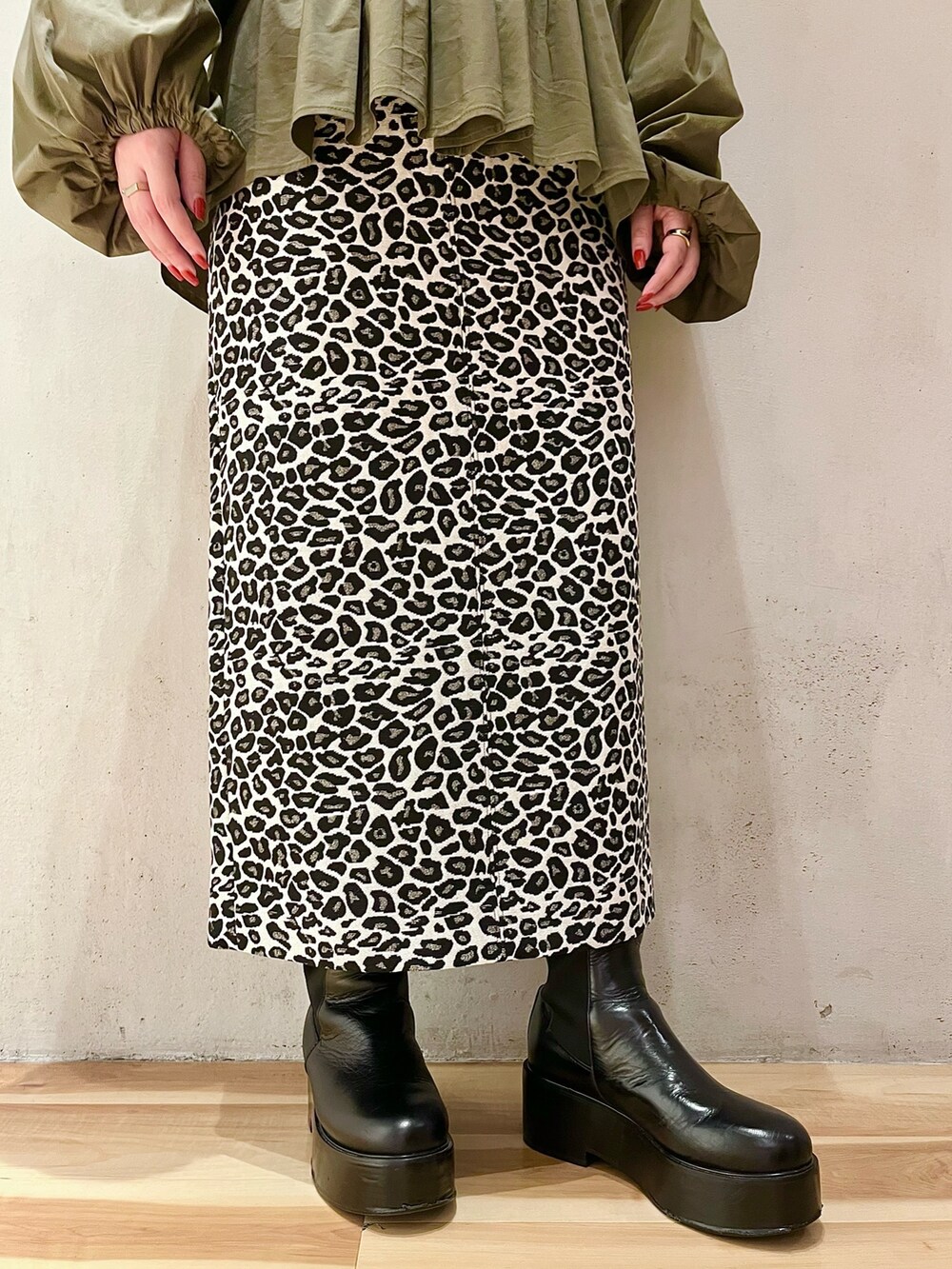 グリーン系のシャツ/ブラウス、ホワイト系のスカート、ブラック系のブーツを着用したレディースの秋コーディネートの7枚目の写真