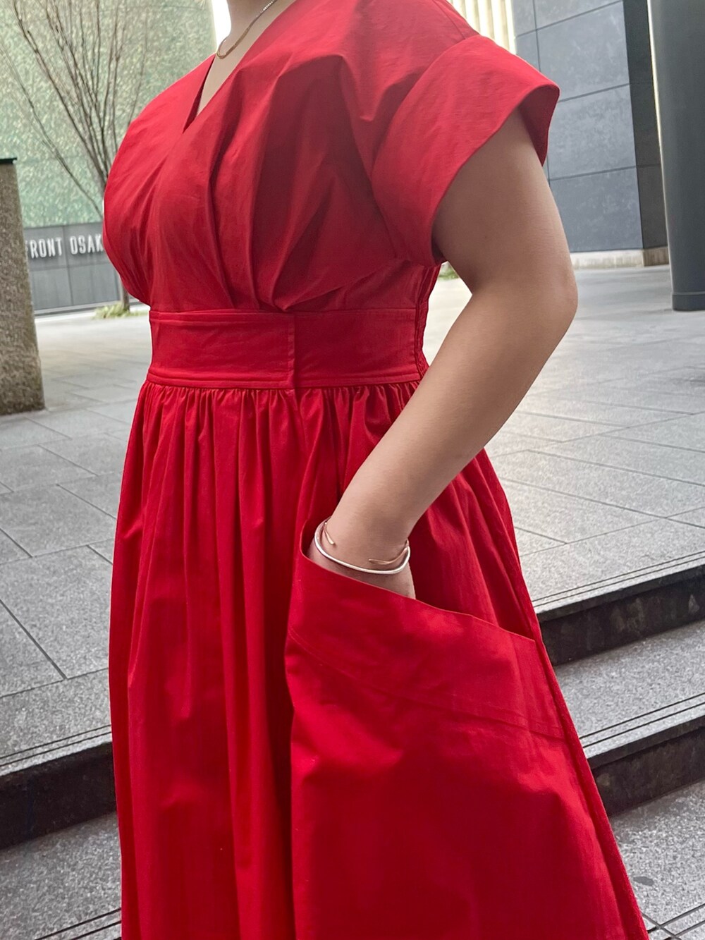 レッド系のワンピース、ホワイト系のハンドバッグ、ホワイト系のサンダルを着用したレディースの冬コーディネートの6枚目の写真