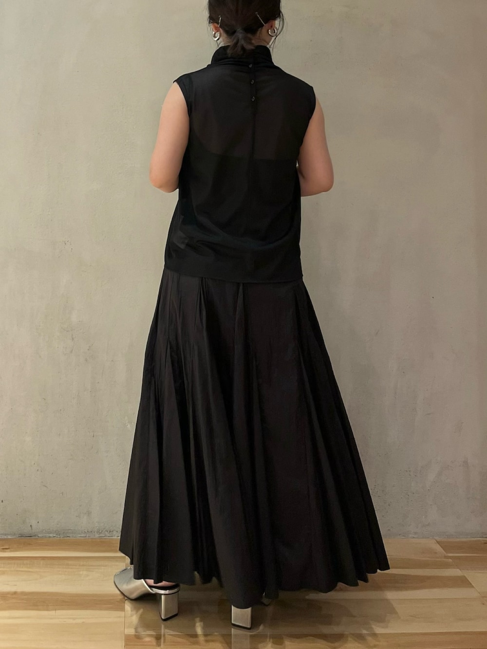 ブラック系のシャツ/ブラウス、ブラック系のスカート、シルバー系のパンプスを着用したレディースの夏コーディネートの3枚目の写真