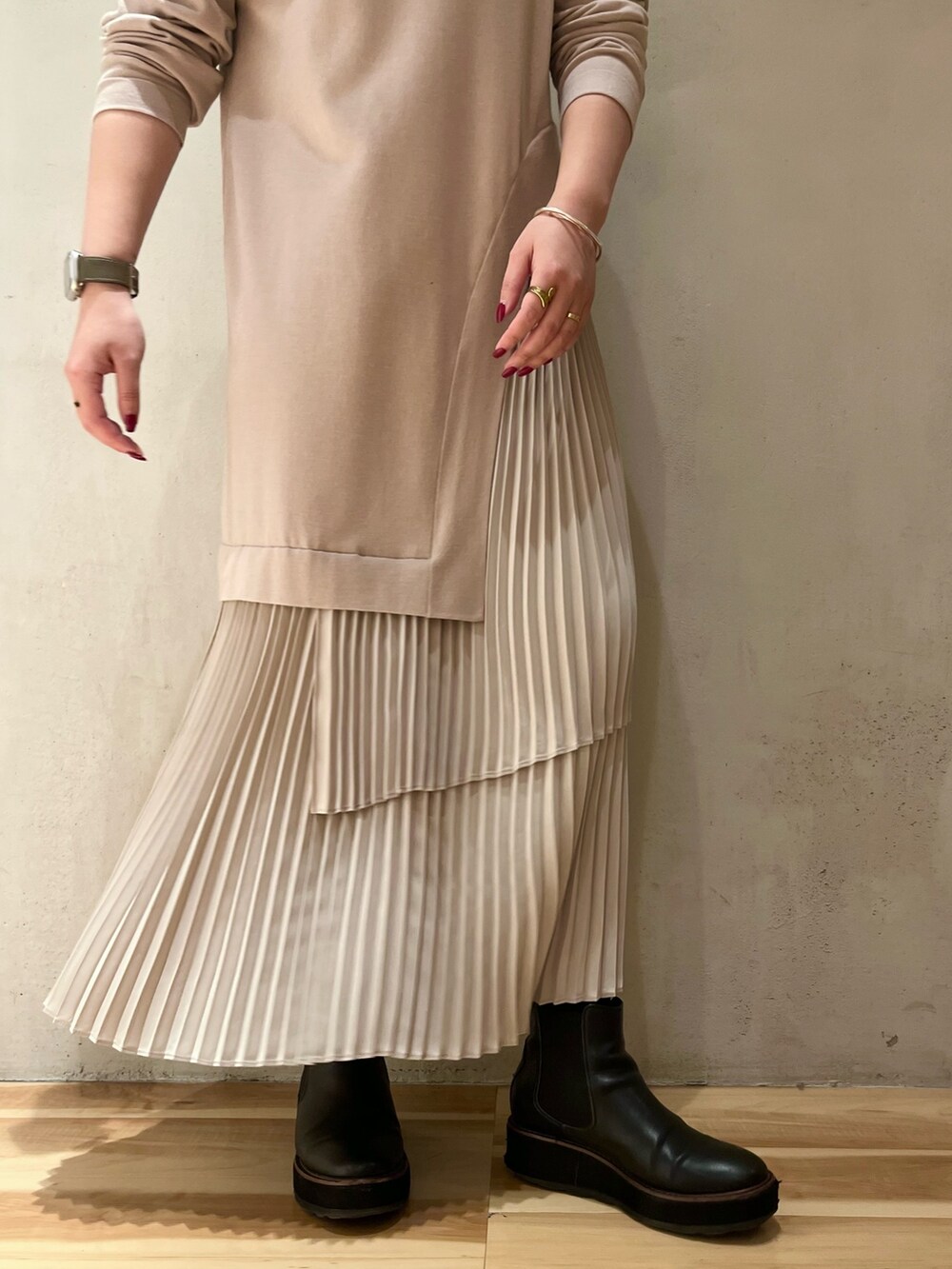 グリーン系のチェスターコート、ブラック系のカーディガン/ボレロ、ベージュ系のワンピースを着用したレディースの冬コーディネートの8枚目の写真