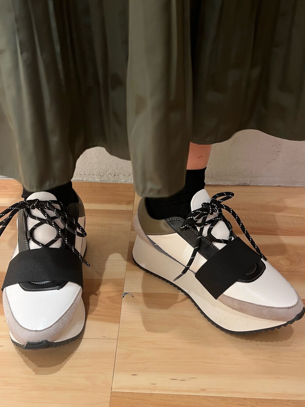 ホワイト系のニット/セーター、ベージュ系のスカート、ブルー系のスニーカーを着用したレディースの秋コーディネートの8枚目の写真