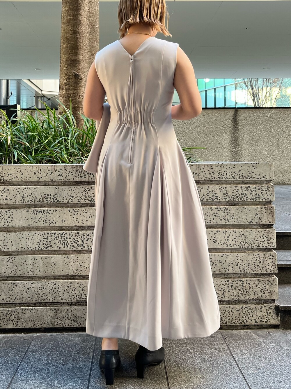 ベージュ系のワンピース、ベージュ系のテーラードジャケット、ブラック系のハンドバッグを着用したレディースの冬コーディネートの6枚目の写真