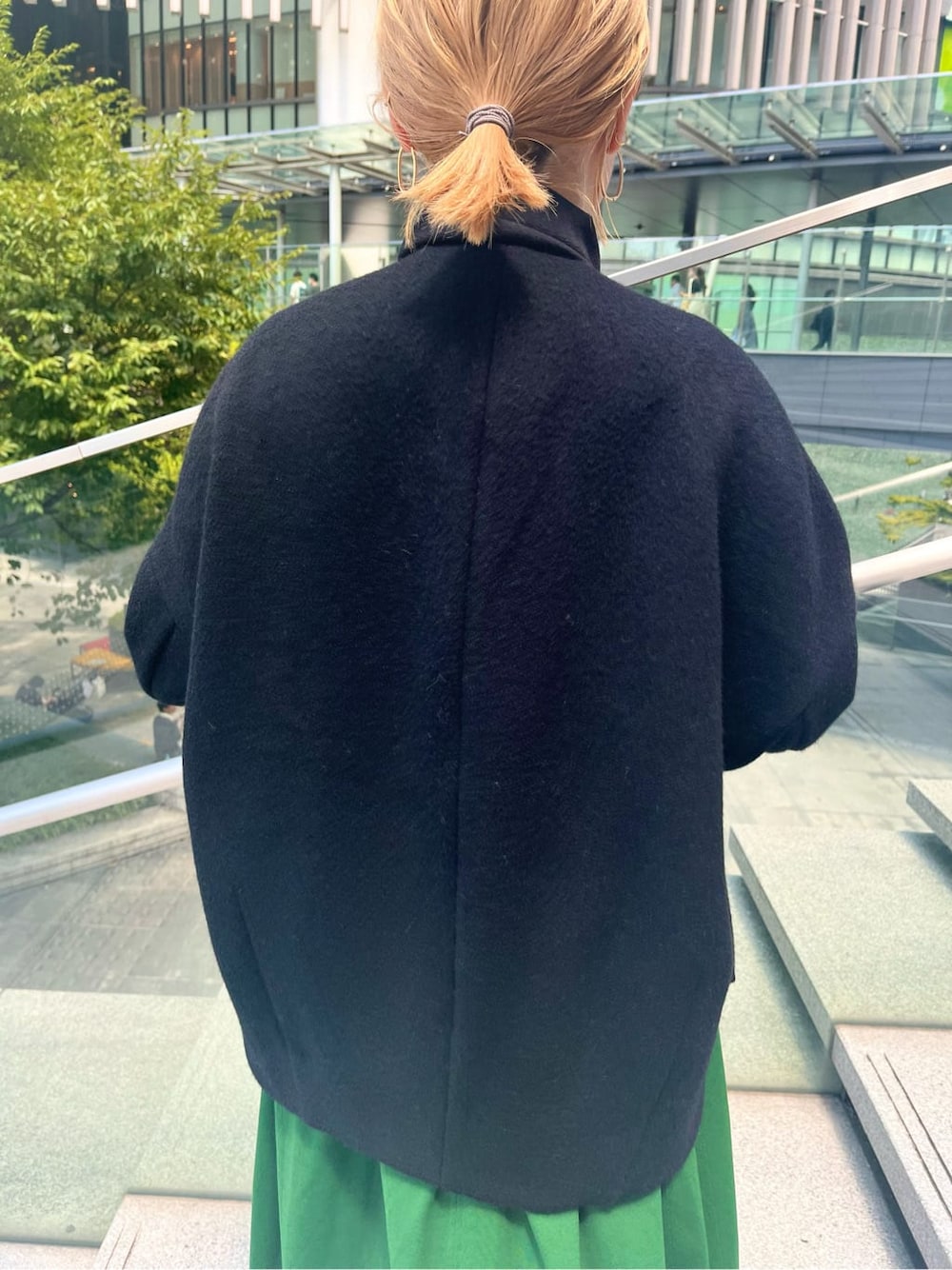 グリーン系のワンピース、ホワイト系のショルダーバッグ、ブラック系のノーカラーコートを着用したレディースの夏コーディネートの7枚目の写真