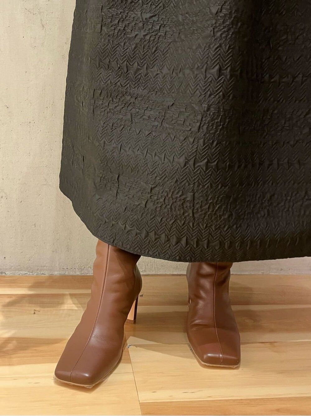 ベージュ系のショルダーバッグ、ホワイト系のカーディガン/ボレロ、ブラウン系のブーツを着用したレディースの秋コーディネートの9枚目の写真