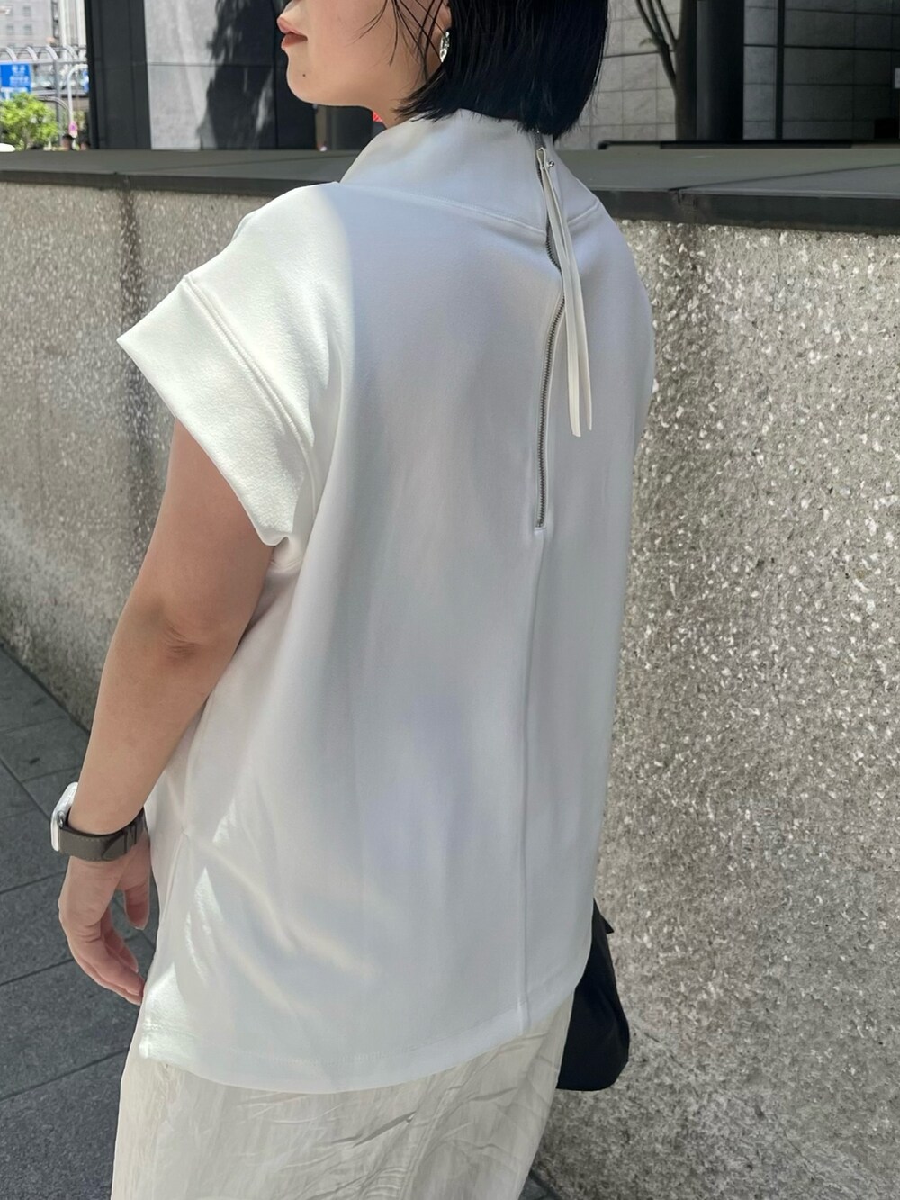 ホワイト系のTシャツ/カットソー、ホワイト系のスカート、ブラック系のサンダルを着用したレディースの春コーディネートの6枚目の写真