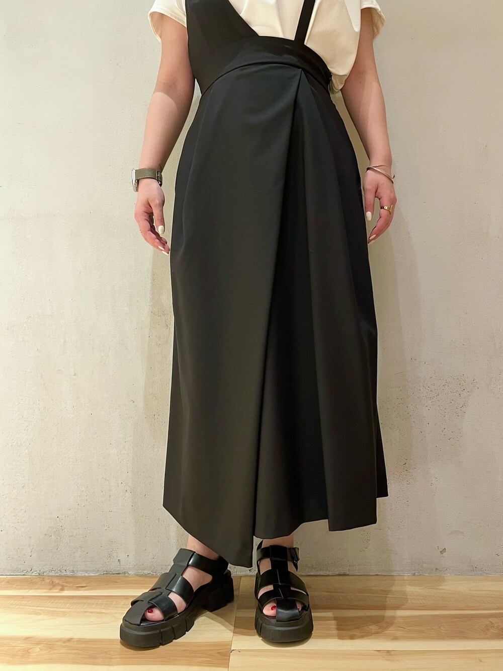 ホワイト系のTシャツ/カットソー、ブラック系のジャンパースカート、シルバー系のネックレスを着用したレディースの春コーディネートの7枚目の写真