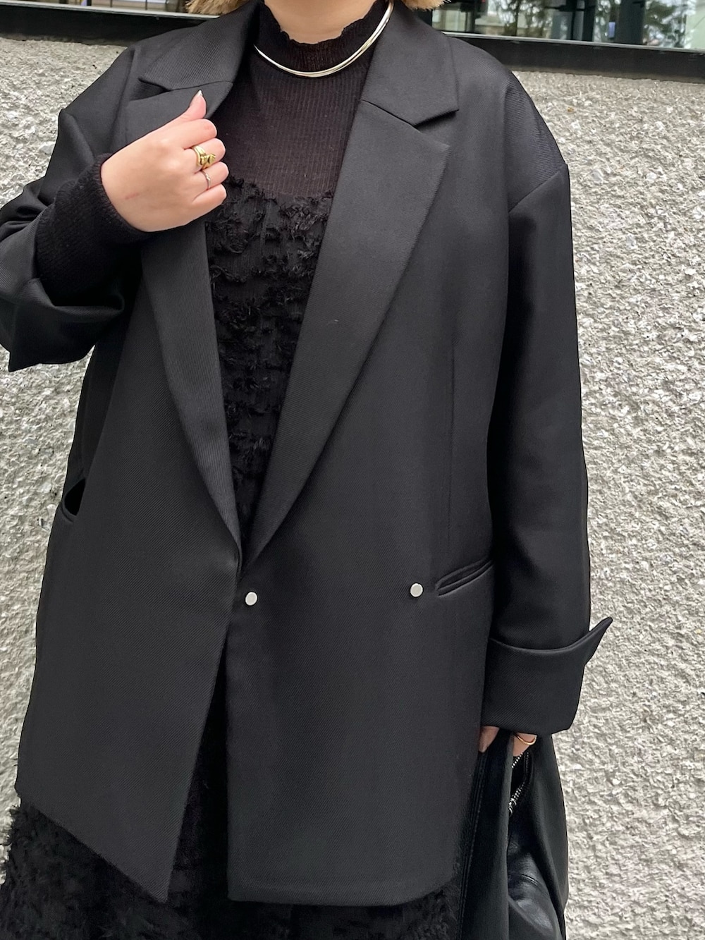 ブラック系のテーラードジャケット、ブラック系のニット/セーター、ブラック系のワンピースを着用したレディースの冬コーディネートの4枚目の写真