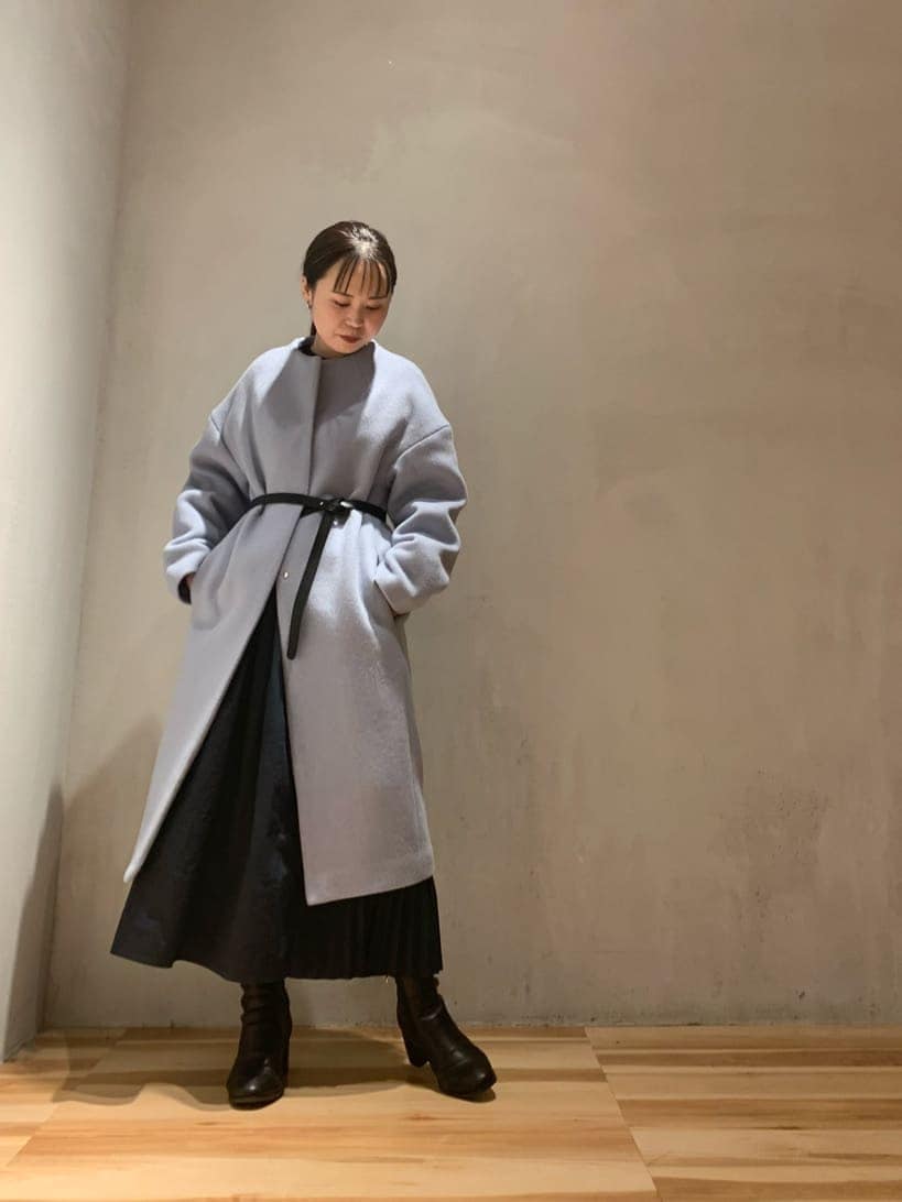 ブラック系のワンピース、ブルー系のノーカラーコートを着用したレディースの秋コーディネートの2枚目の写真