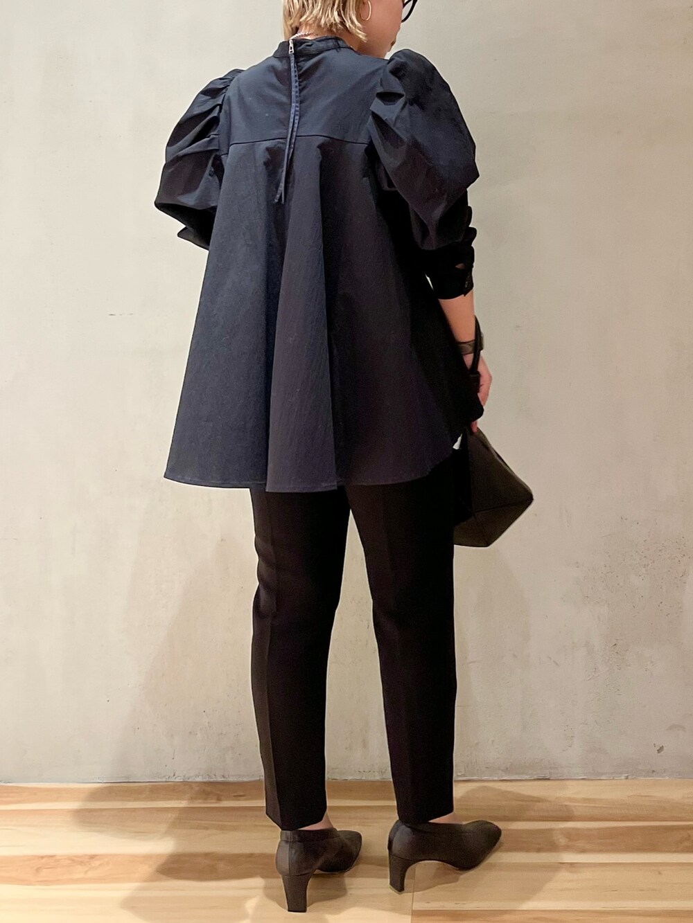 ブラック系のハンドバッグ、ブラック系のその他パンツ、ブラック系のシャツ/ブラウスを着用したレディースの冬コーディネートの3枚目の写真