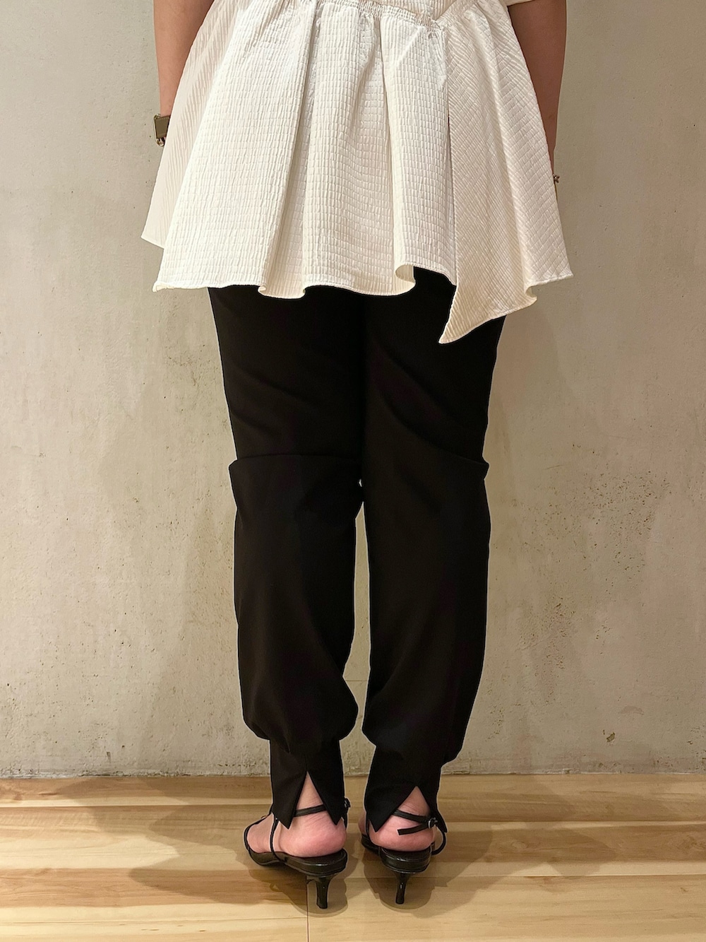 ブラック系のノーカラーコート、ホワイト系のシャツ/ブラウス、ブラック系のスラックスを着用したレディースの夏コーディネートの10枚目の写真