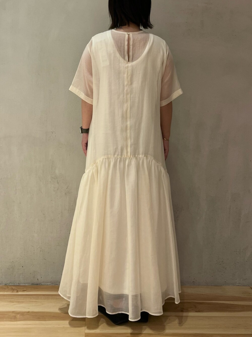 ホワイト系のワンピース、ブラック系のサンダルを着用したレディースの夏コーディネートの4枚目の写真