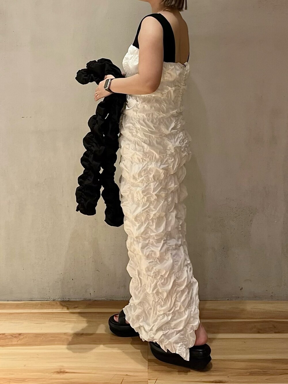 ホワイト系のワンピース、ブラック系のカーディガン/ボレロを着用したレディースの冬コーディネートの2枚目の写真