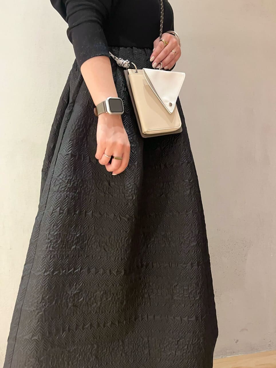 ベージュ系のショルダーバッグ、ブラウン系のブーツ、ブラック系のワンピースを着用したレディースの秋コーディネートの7枚目の写真