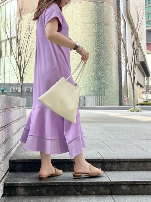 パープル系のワンピース、ホワイト系のハンドバッグを着用したレディースの春コーディネートの2枚目の写真