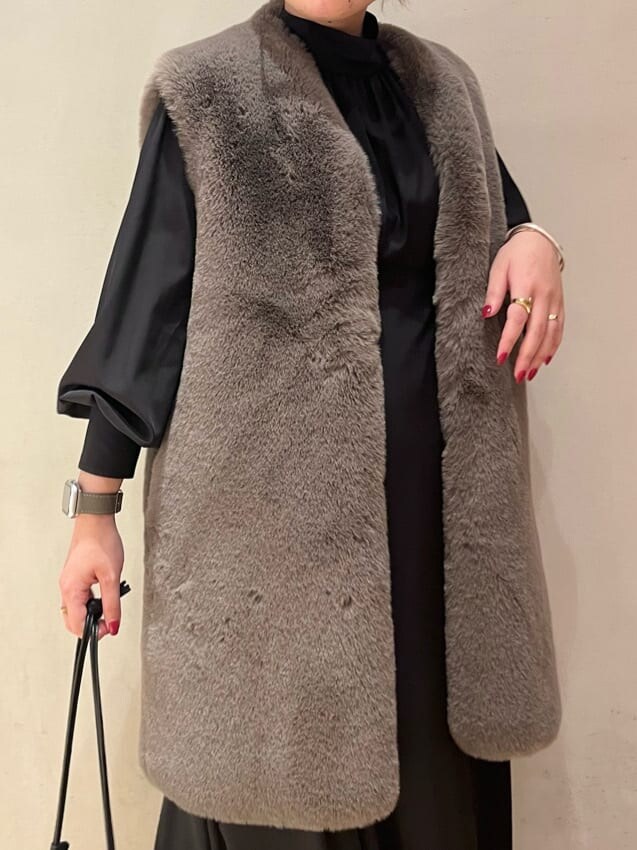 ブラック系のブーツ、ブラック系のワンピース、ブラウン系のその他アウターを着用したレディースの秋コーディネートの6枚目の写真