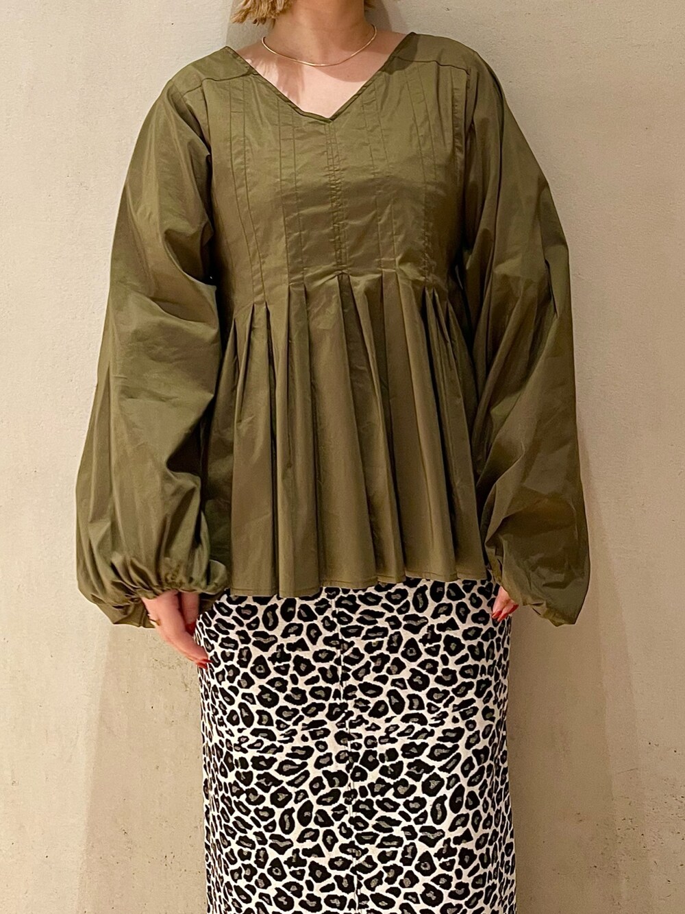 グリーン系のシャツ/ブラウス、ホワイト系のスカート、ブラック系のブーツを着用したレディースの秋コーディネートの4枚目の写真