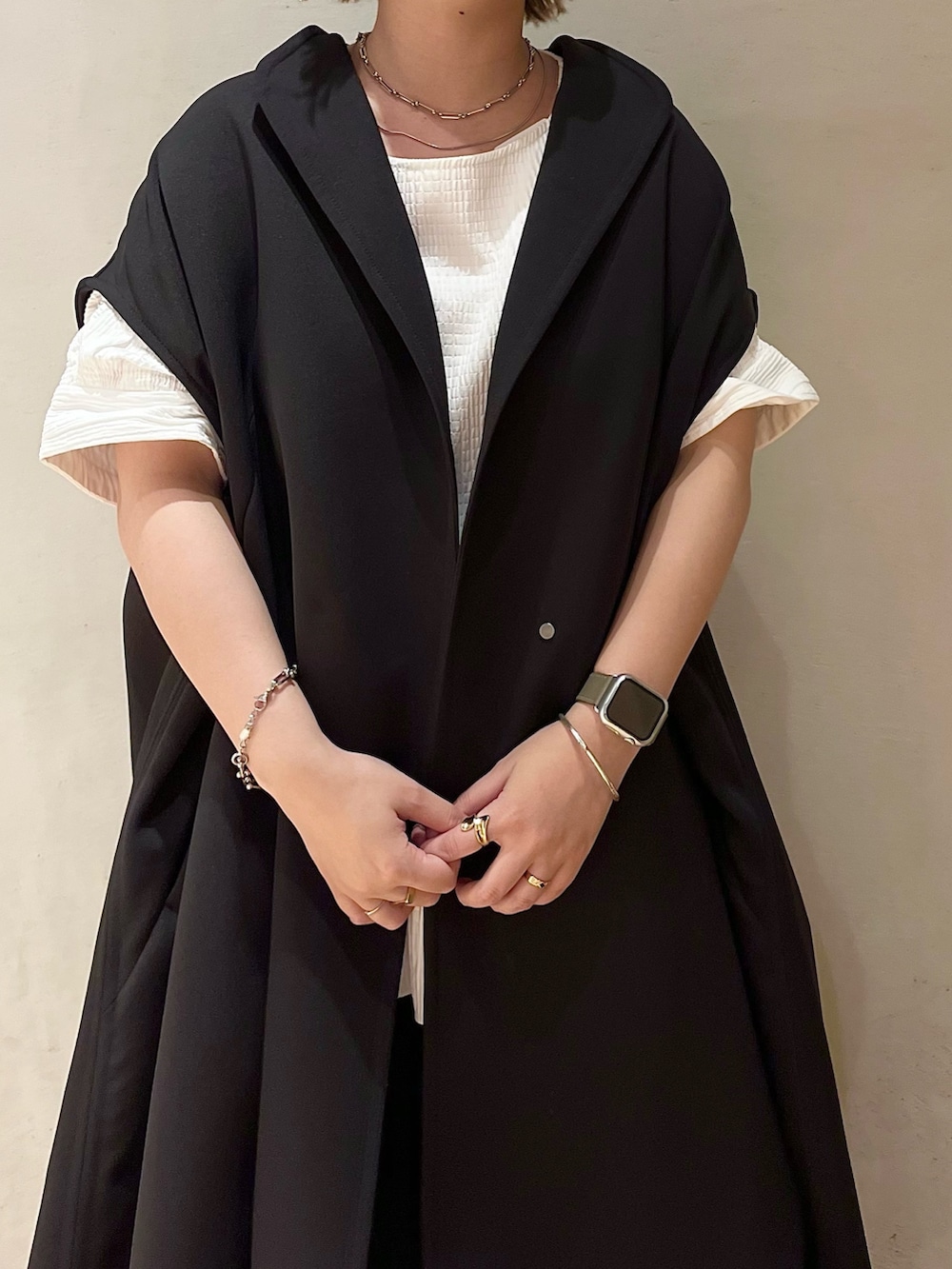 ブラック系のノーカラーコート、ホワイト系のシャツ/ブラウス、ブラック系のスラックスを着用したレディースの夏コーディネートの4枚目の写真