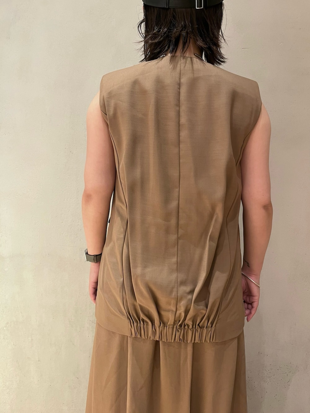 ベージュ系のワンピース、ブラック系のブーツ、ブラック系のキャップを着用したレディースの夏コーディネートの7枚目の写真