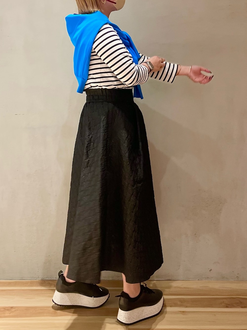 ブルー系のカーディガン/ボレロ、ブラック系のスカート、ブラック系のスニーカーを着用したレディースの春コーディネートの2枚目の写真