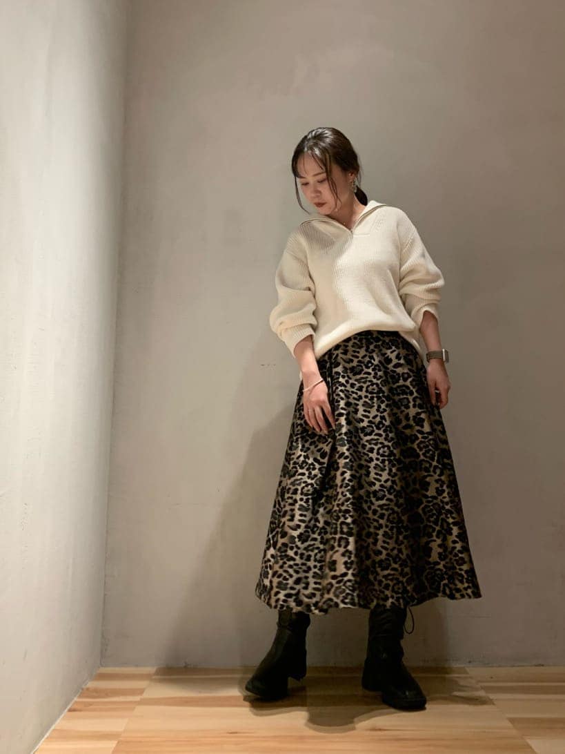 その他のスカート、ブラック系のブーツ、ホワイト系のニット/セーターを着用したレディースの秋コーディネートの2枚目の写真