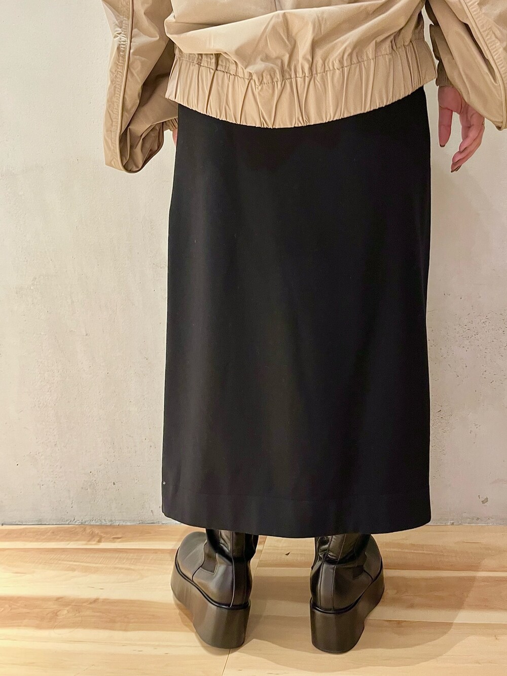 ベージュ系のブルゾン、ブラック系のスカート、ブラック系のブーツを着用したレディースの秋コーディネートの8枚目の写真