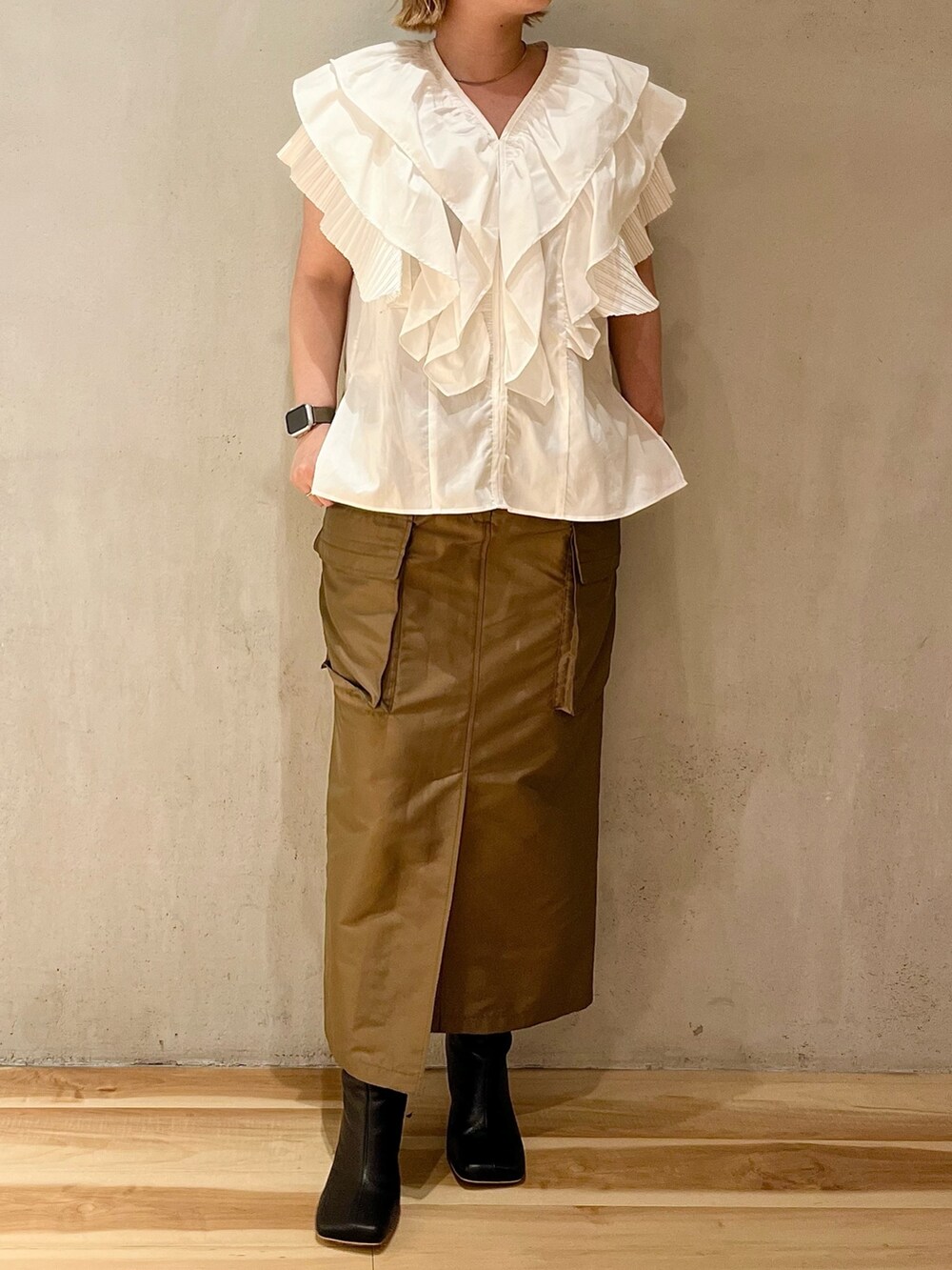 ホワイト系のシャツ/ブラウス、ブラウン系のスカート、ブラック系のブーツを着用したレディースの春コーディネートの4枚目の写真