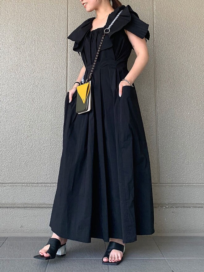 ブラック系のサンダル、ブラック系のワンピース、ブラウン系のショルダーバッグを着用したレディースの夏コーディネートの2枚目の写真