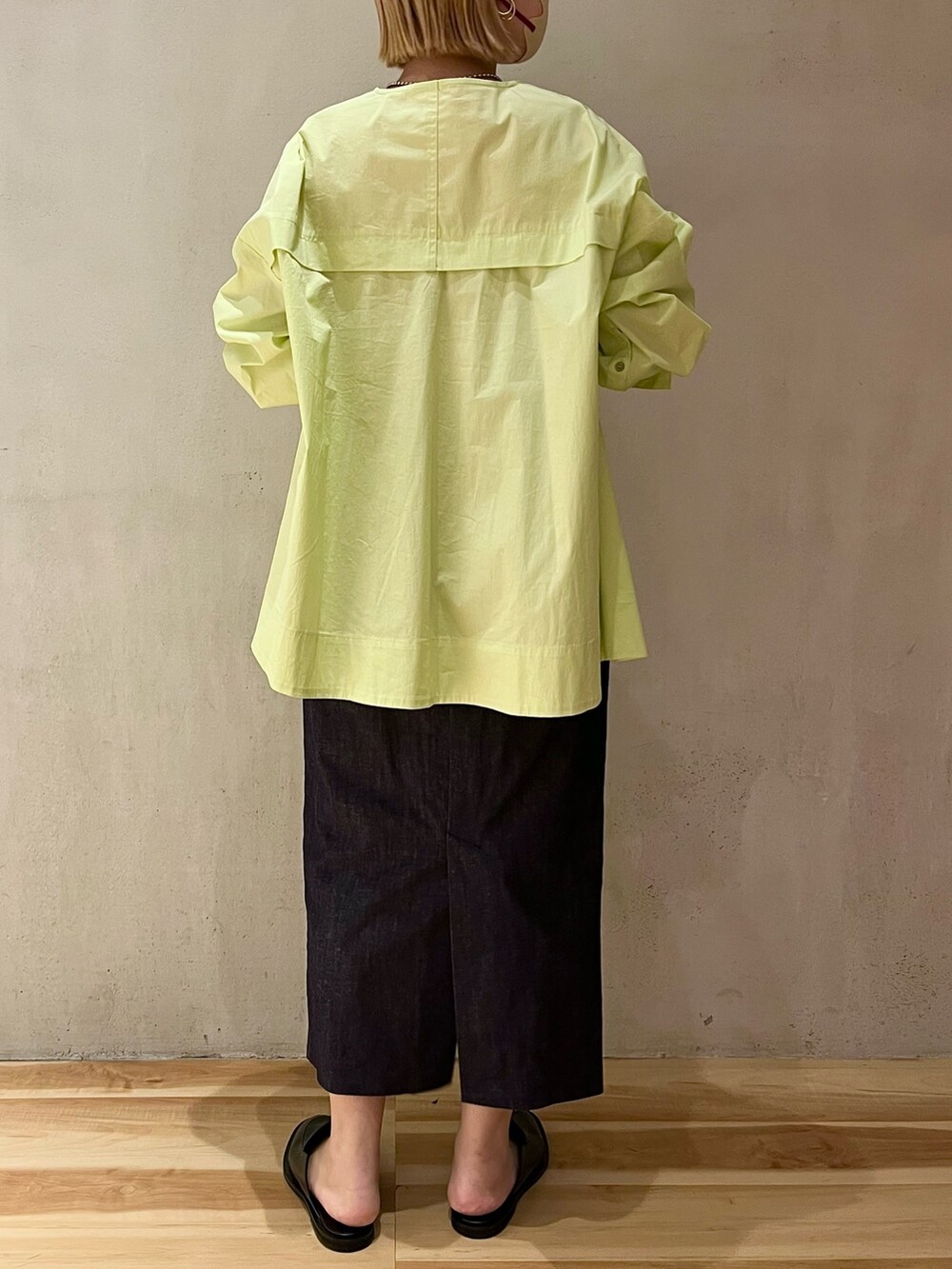 イエロー系のシャツ/ブラウス、ブルー系のスカート、シルバー系のネックレスを着用したレディースの春コーディネートの3枚目の写真