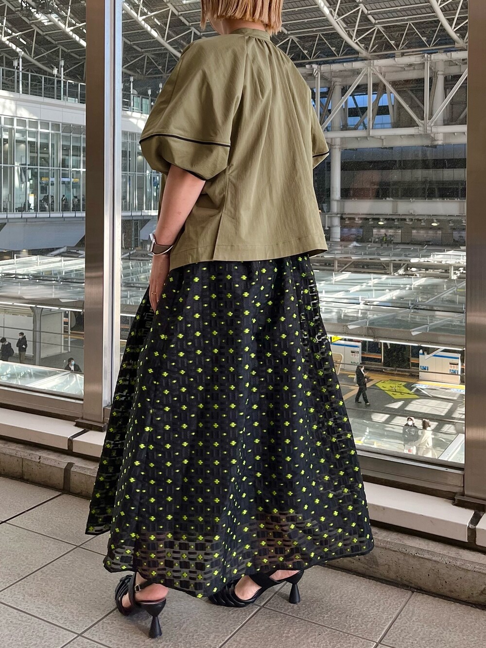 グリーン系のブルゾン、ホワイト系のタンクトップ、その他のスカートを着用したレディースの春コーディネートの2枚目の写真