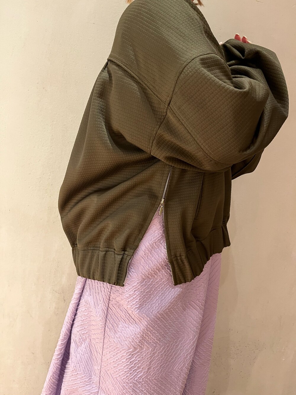 グリーン系のブルゾン、パープル系のワンピースを着用したレディースの春コーディネートの5枚目の写真