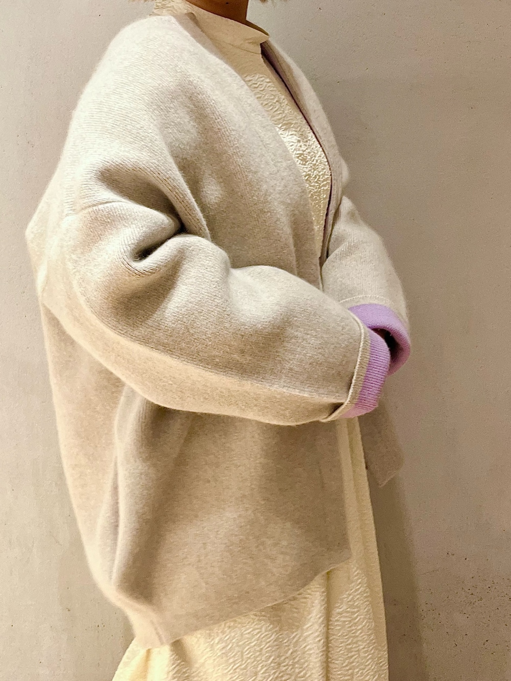 ホワイト系のノーカラージャケット、ホワイト系のワンピース、ベージュ系のブーツを着用したレディースの秋コーディネートの5枚目の写真