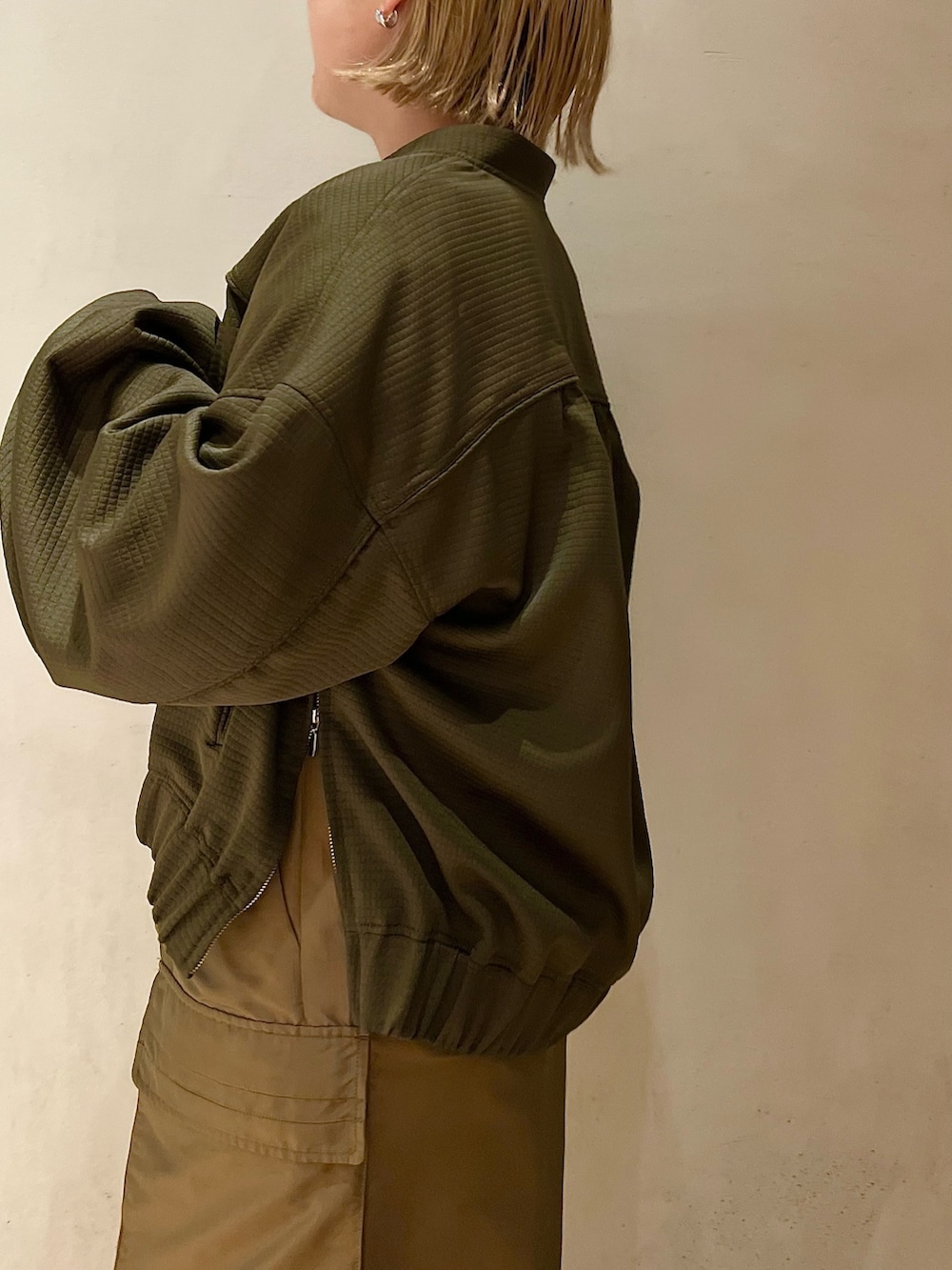 ブラウン系のスカート、ブラック系のブーツ、ブラック系のニット/セーターを着用したレディースの春コーディネートの4枚目の写真