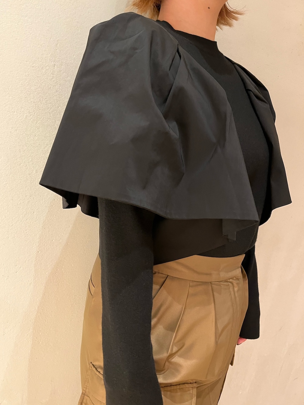 ブラウン系のスカート、ブラック系のブーツ、ブラック系のニット/セーターを着用したレディースの春コーディネートの9枚目の写真