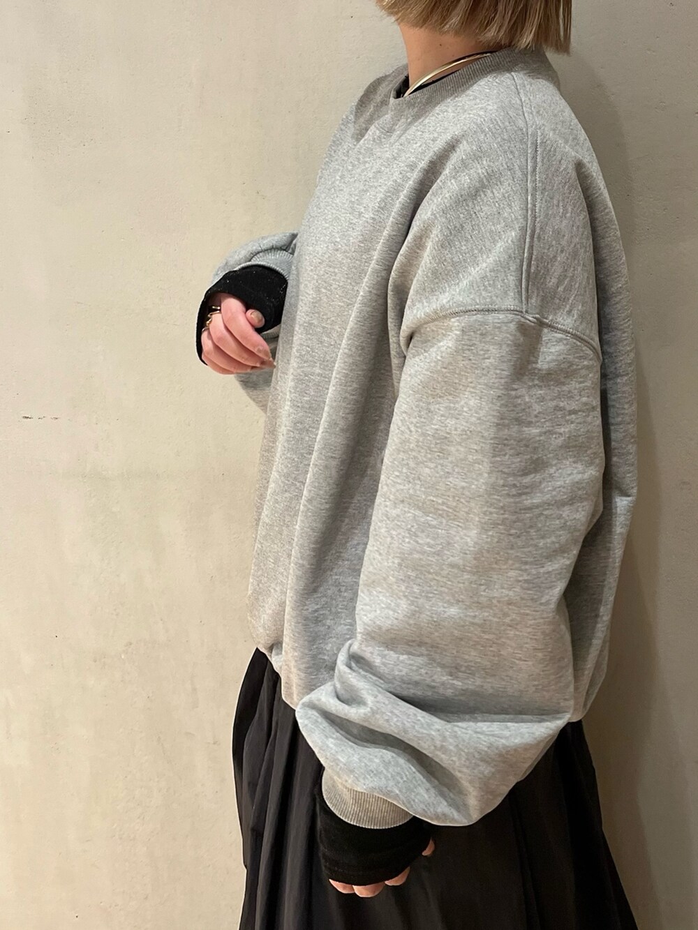 グレー系のスウェット、ブラック系のTシャツ/カットソー、ブラック系のスカートを着用したレディースの冬コーディネートの6枚目の写真