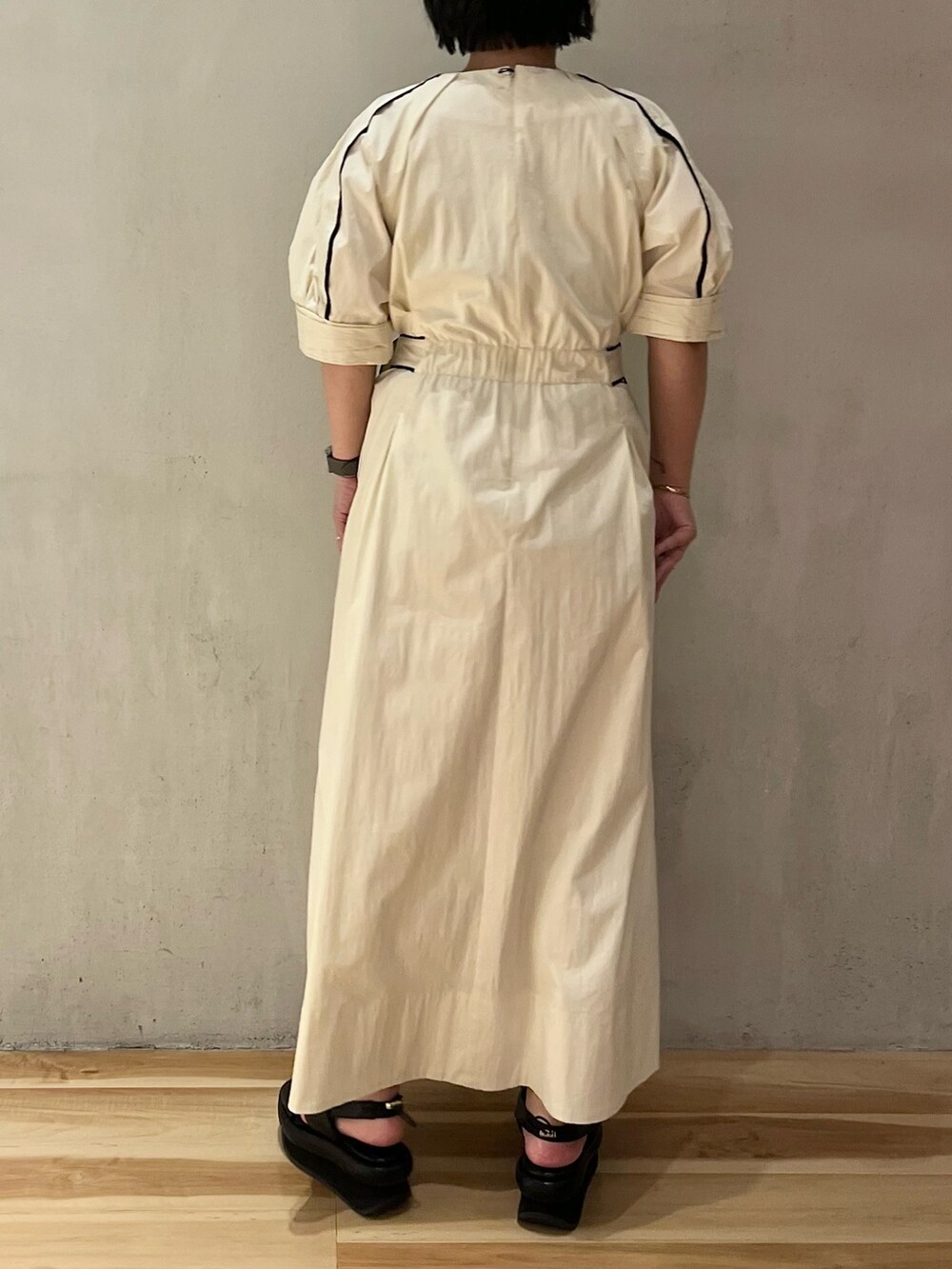 ホワイト系のワンピース、ブラック系のサンダルを着用したレディースの冬コーディネートの3枚目の写真