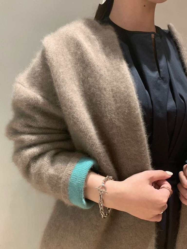 ブラック系のワンピース、ブラック系のブーツ、ベージュ系のカーディガン/ボレロを着用したレディースの秋コーディネートの3枚目の写真