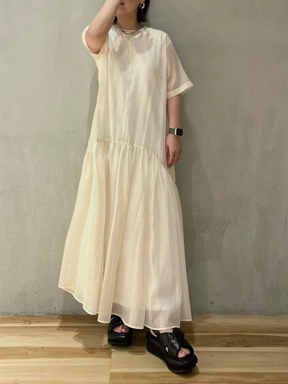 ホワイト系のワンピース、ブラック系のサンダルを着用したレディースの夏コーディネートの2枚目の写真