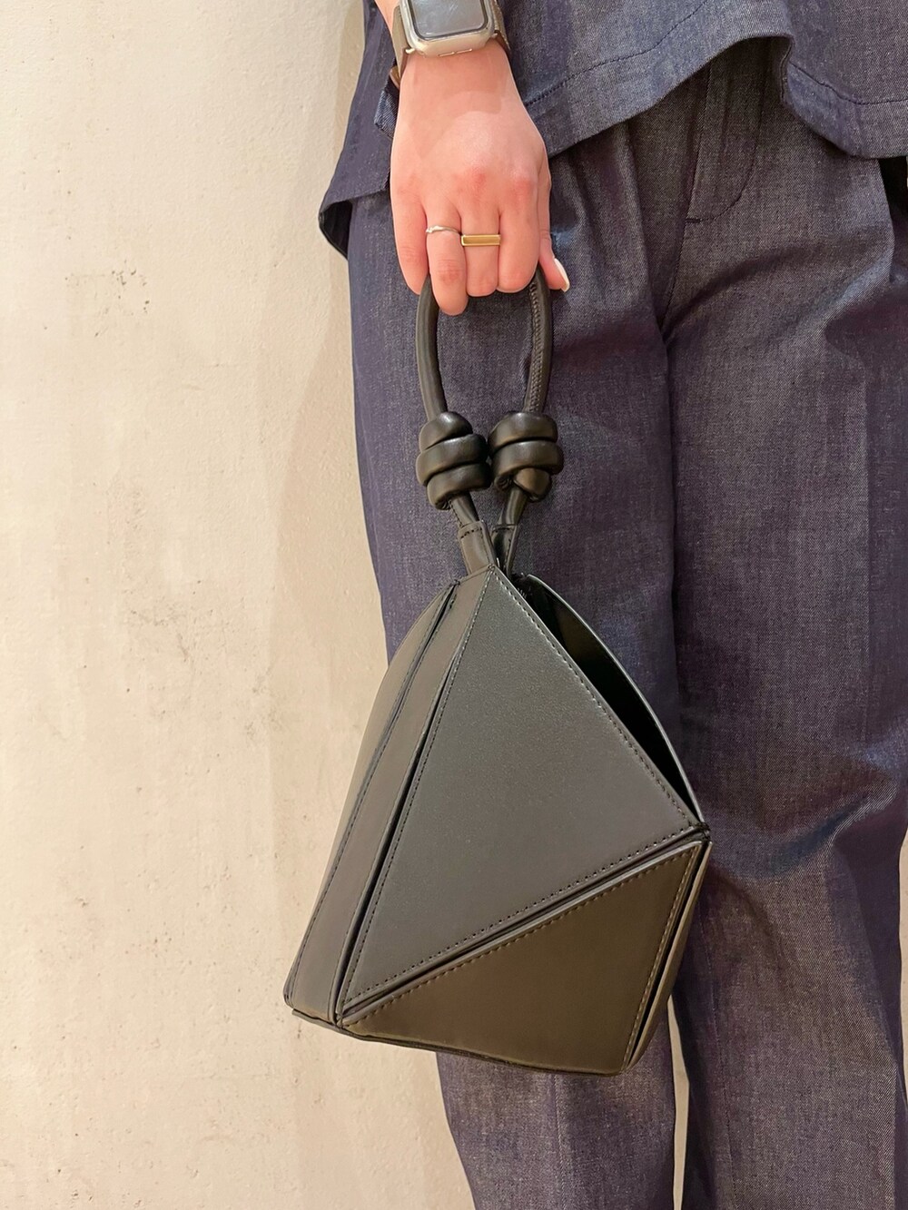 ブラック系のハンドバッグ、ブラック系のサンダル、ブルー系のブルゾンを着用したレディースの春コーディネートの9枚目の写真