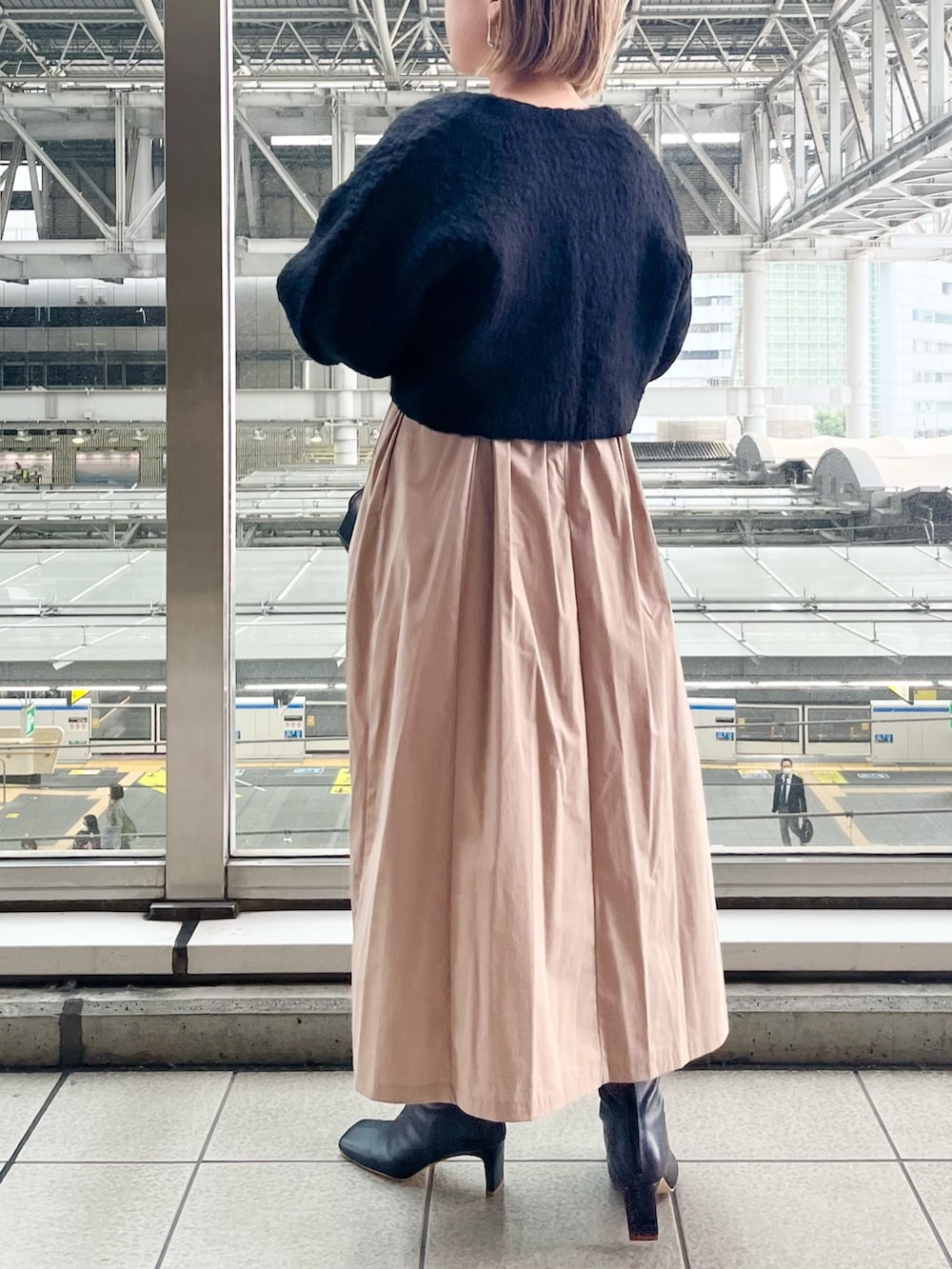 ブラック系のワンピース、ブラック系のハンドバッグ、ブラック系のブーツを着用したレディースの秋コーディネートの3枚目の写真