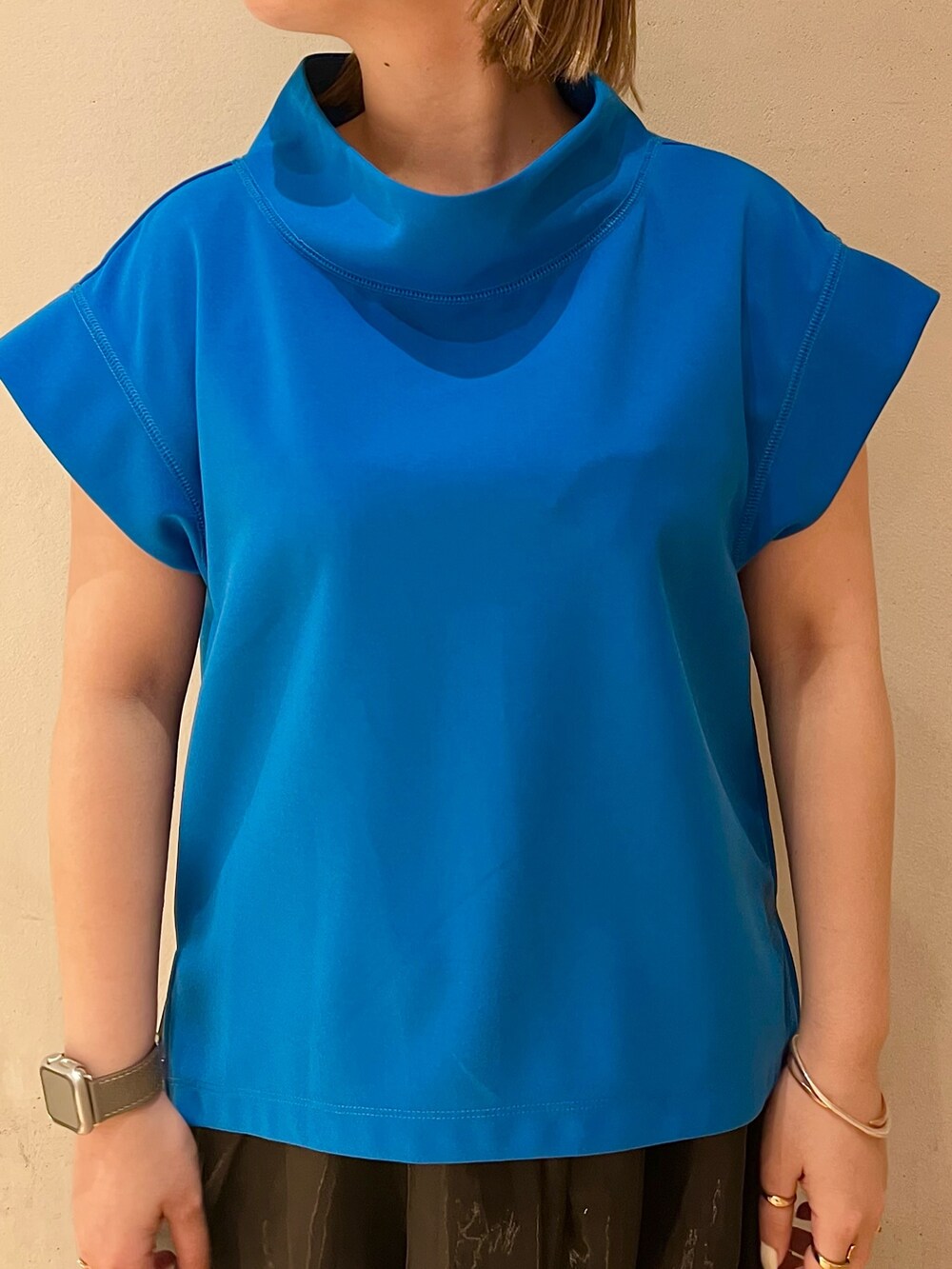 ブルー系のTシャツ/カットソー、ブラック系のスカート、ブラック系のサンダルを着用したレディースの冬コーディネートの5枚目の写真