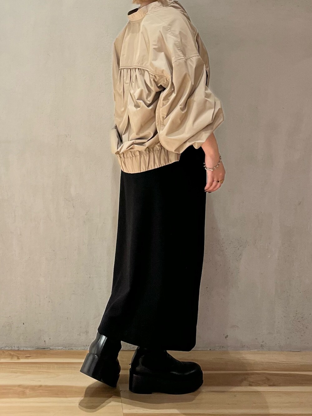 ベージュ系のブルゾン、ブラック系のスカート、ブラック系のブーツを着用したレディースの秋コーディネートの4枚目の写真