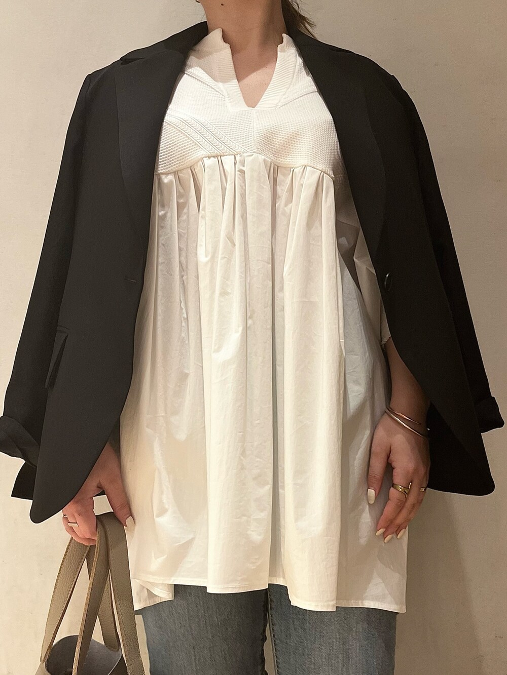 ブラック系のテーラードジャケット、ホワイト系のシャツ/ブラウス、ブルー系のデニムパンツを着用したレディースの冬コーディネートの4枚目の写真