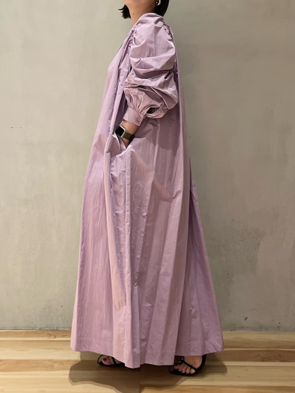 パープル系のワンピース、ブラック系のショルダーバッグを着用したレディースの春コーディネートの2枚目の写真