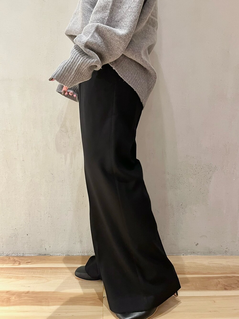 グレー系のニット/セーター、ブラック系のその他パンツ、ブラック系のブーツを着用したレディースの秋コーディネートの10枚目の写真