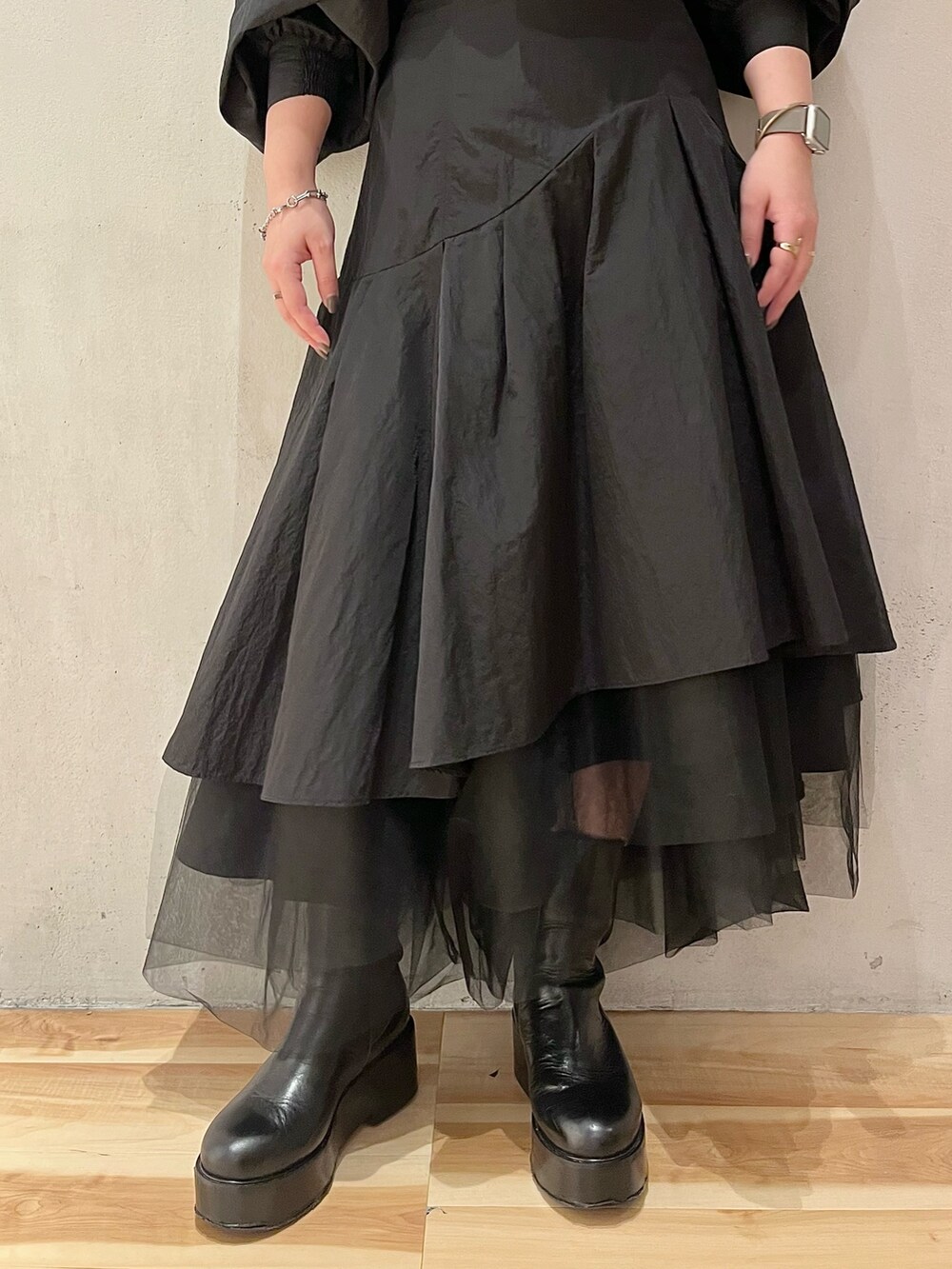 ブラック系のシャツ/ブラウス、ブラック系のスカート、ブラック系のブーツを着用したレディースの秋コーディネートの9枚目の写真