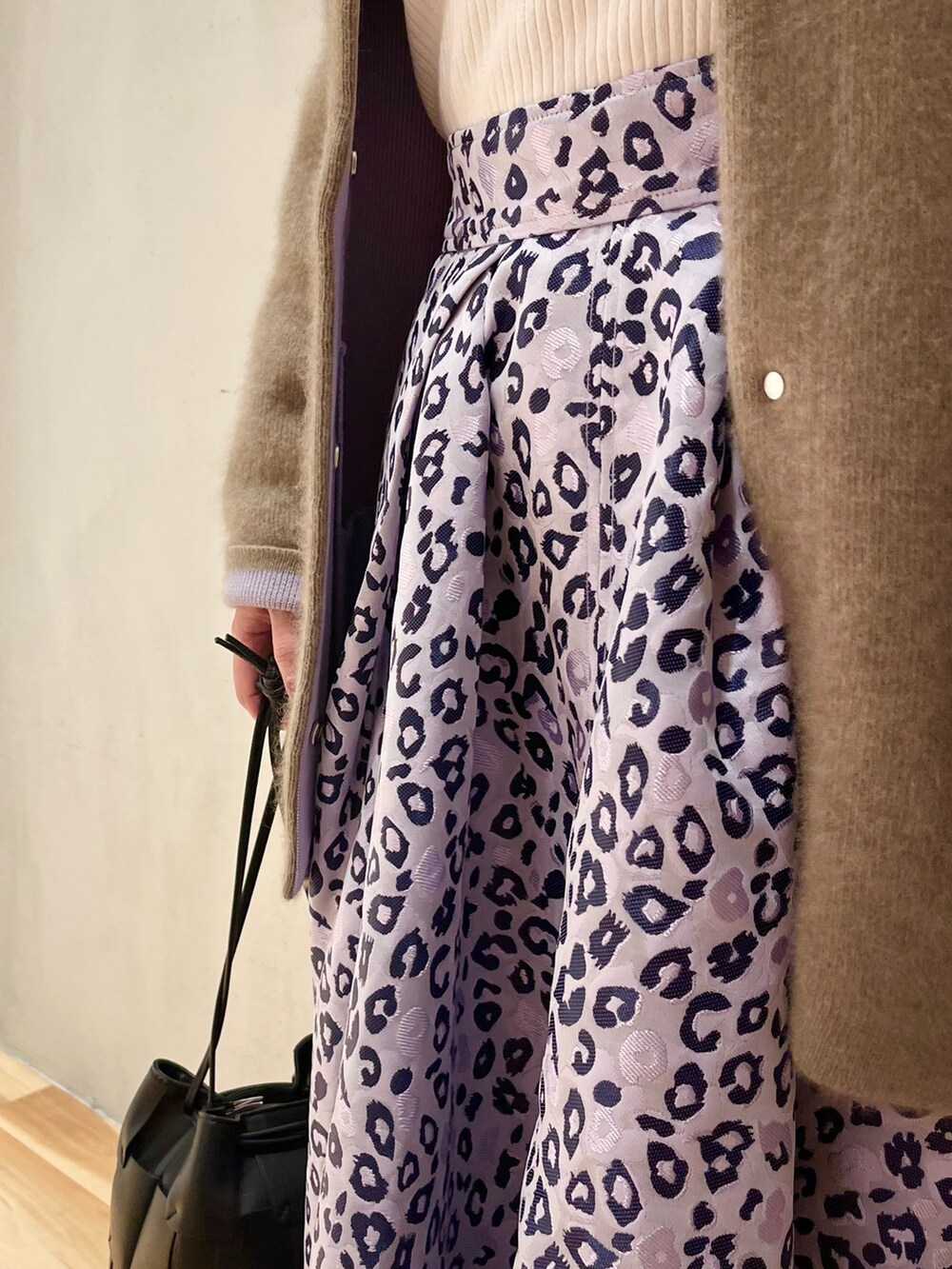 ホワイト系のニット/セーター、パープル系のスカート、ブラウン系のブーツを着用したレディースの冬コーディネートの8枚目の写真