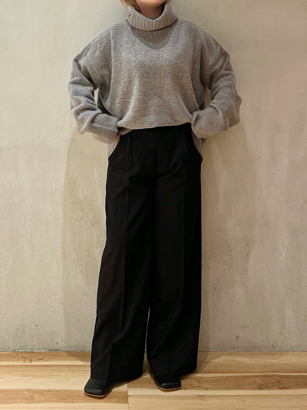 グレー系のニット/セーター、ブラック系のその他パンツ、ブラック系のブーツを着用したレディースの秋コーディネートの4枚目の写真